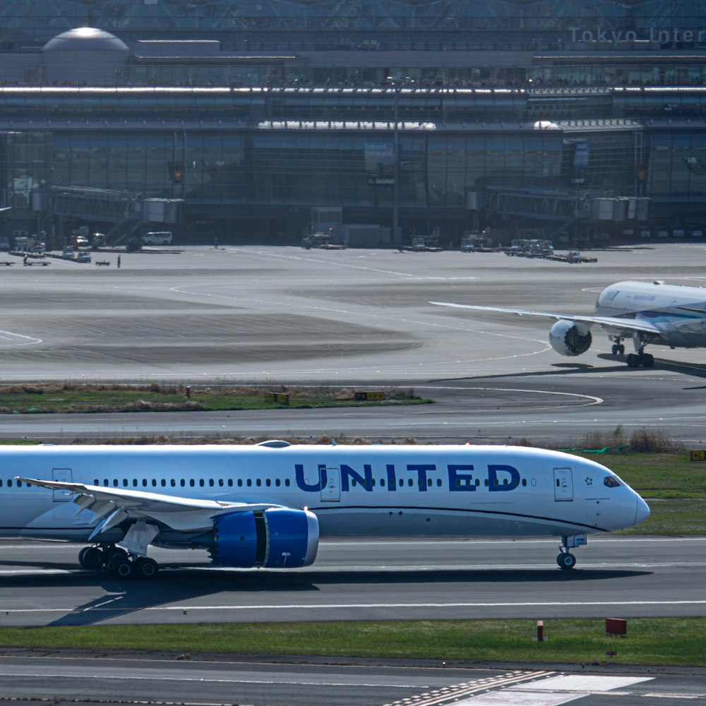 a united airlines plane on a runway at an airport