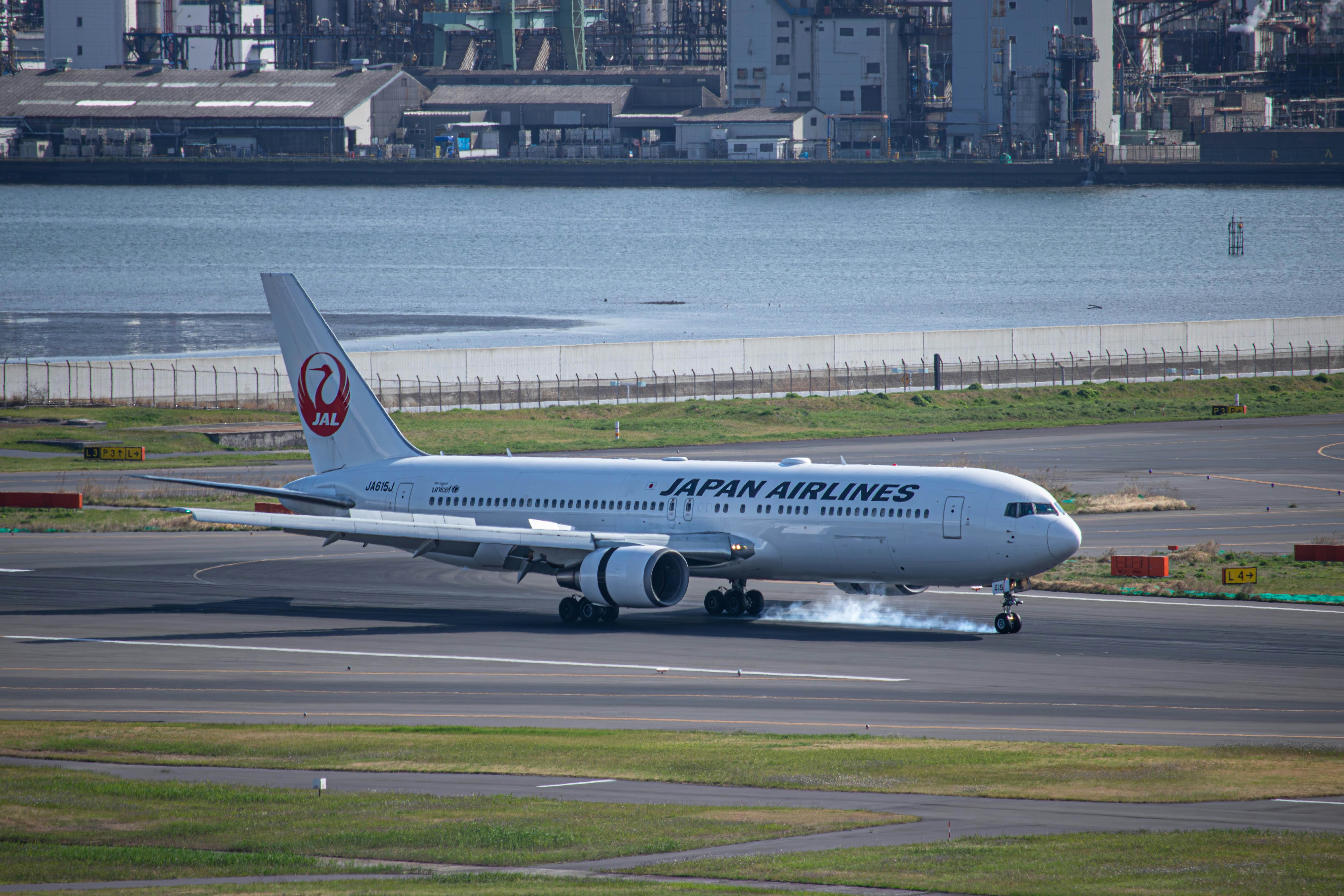 a japan airlines plane on the runway of an airport, 