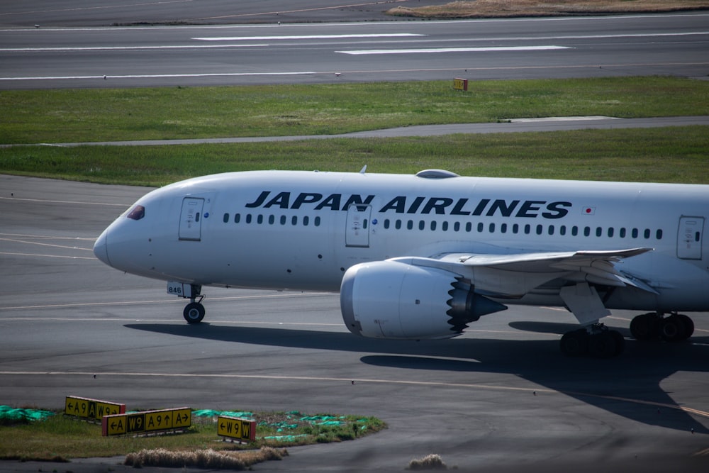 a japan airlines airplane on the runway at an airport