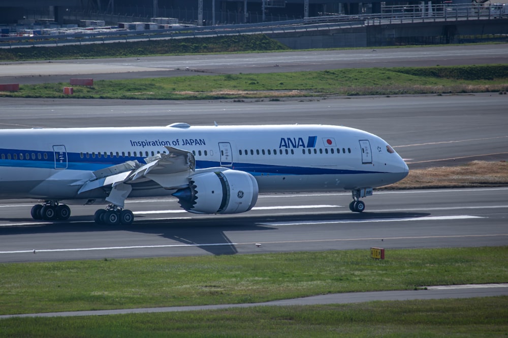 un grande aereo di linea seduto in cima alla pista di un aeroporto