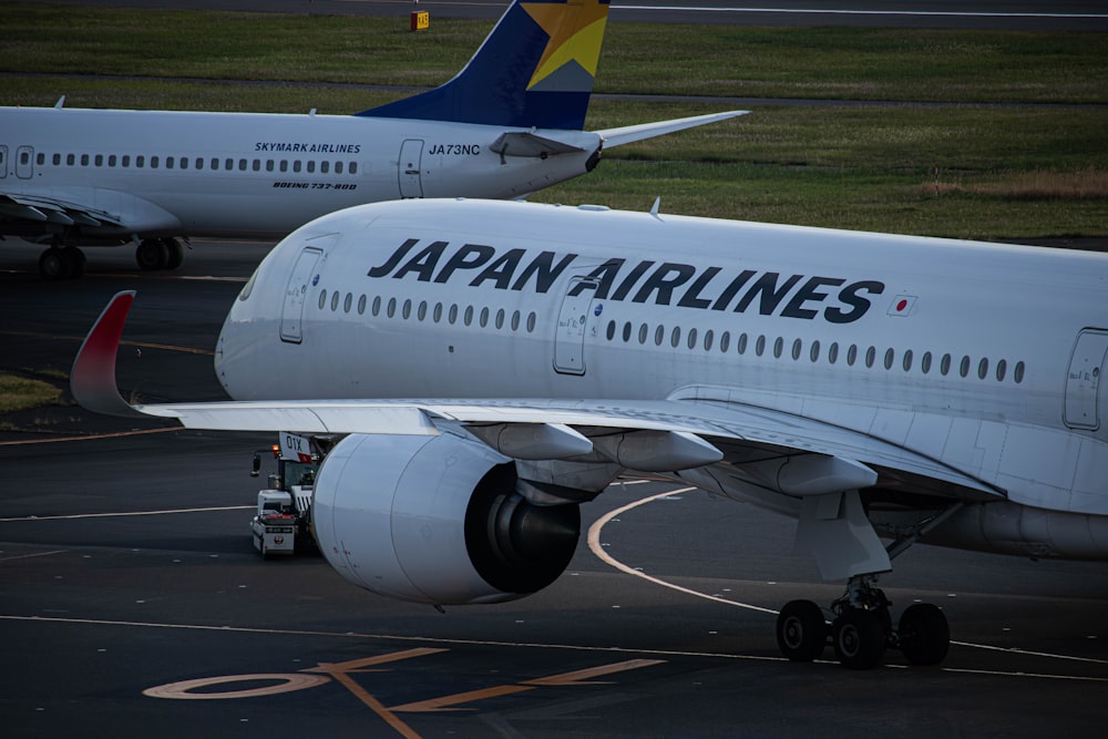 two japan airlines planes parked on the tarmac
