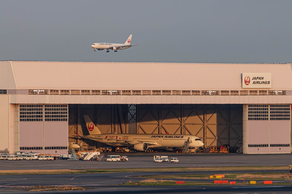 a large jetliner flying over a runway at an airport