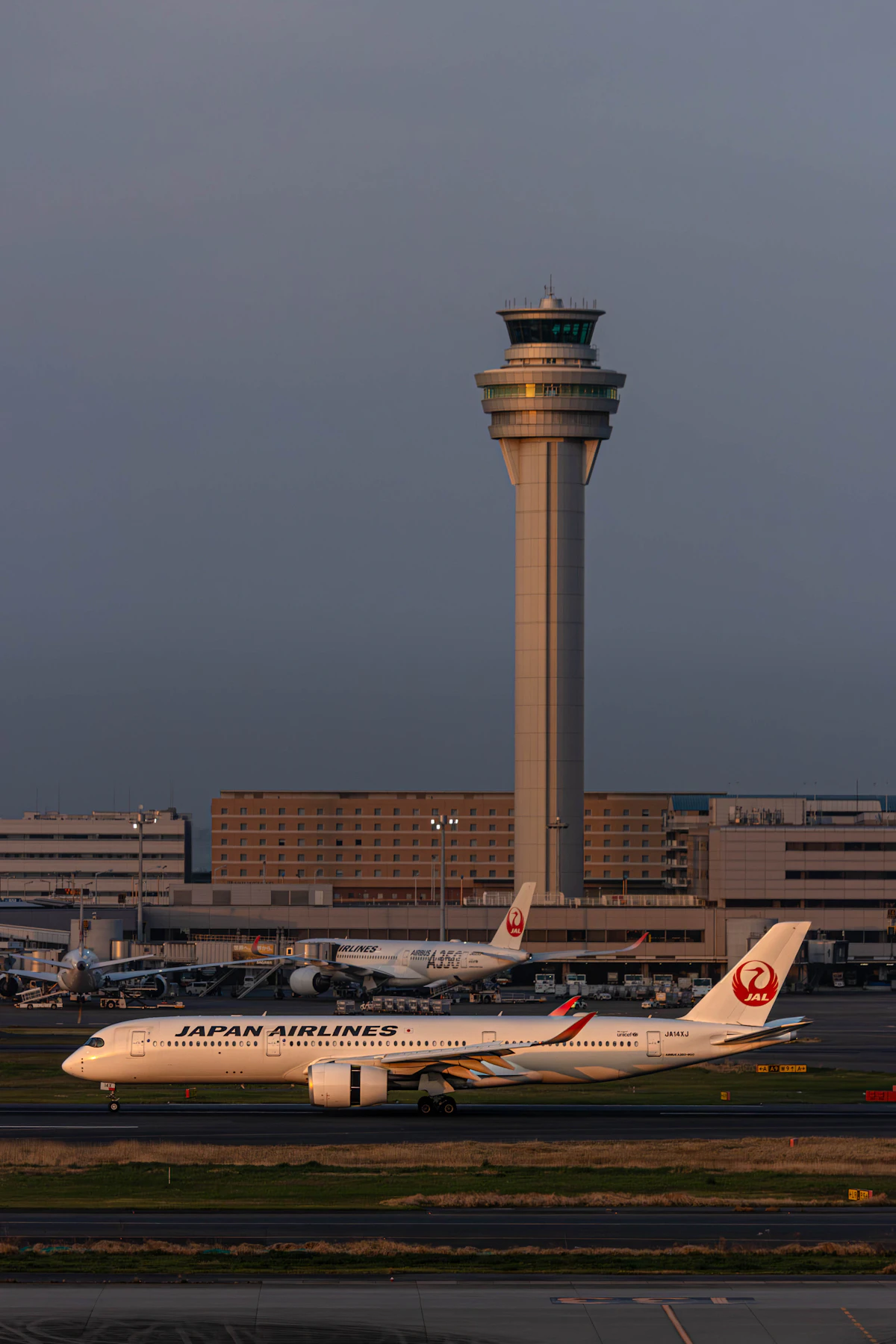An air traffic control tower silhouetted against an overcast sky
