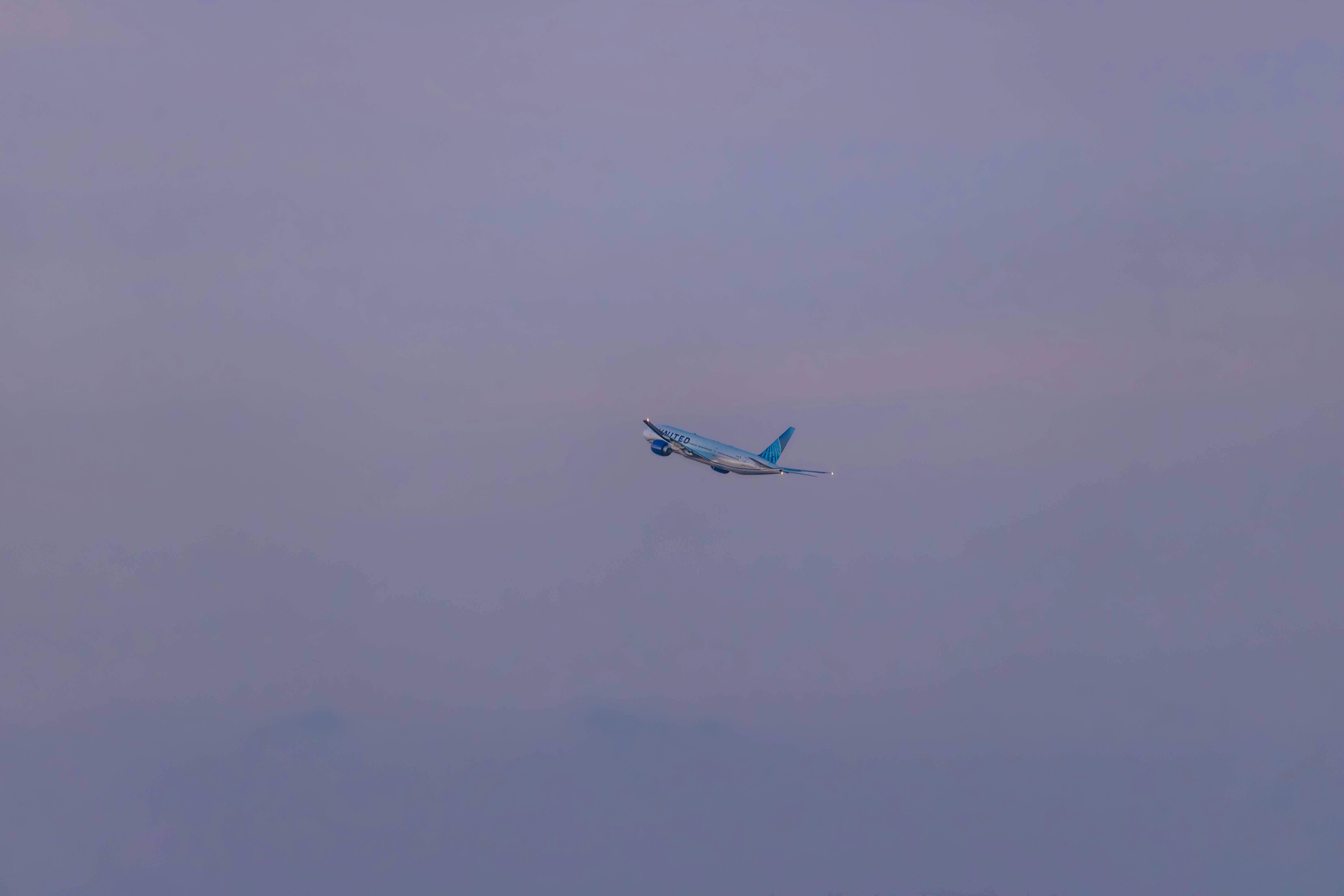 an airplane flying in the sky on a cloudy day