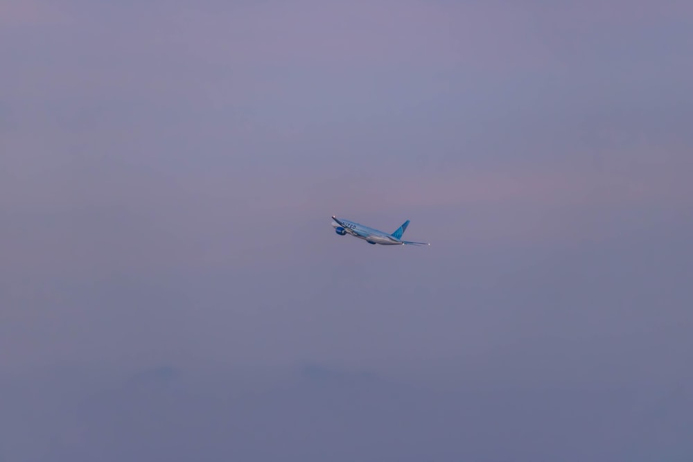 an airplane flying in the sky on a cloudy day