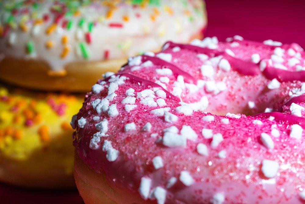 a close up of three doughnuts with sprinkles