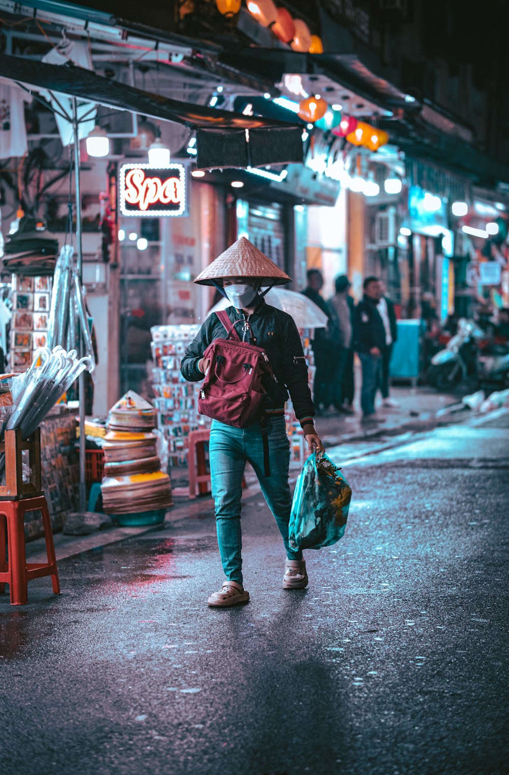 ein Mann, der mit einem Regenschirm eine Straße entlanggeht