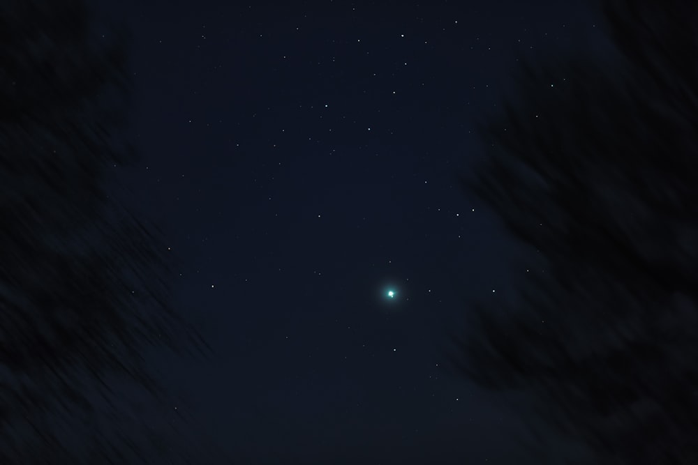 a night sky with stars and a bright green object