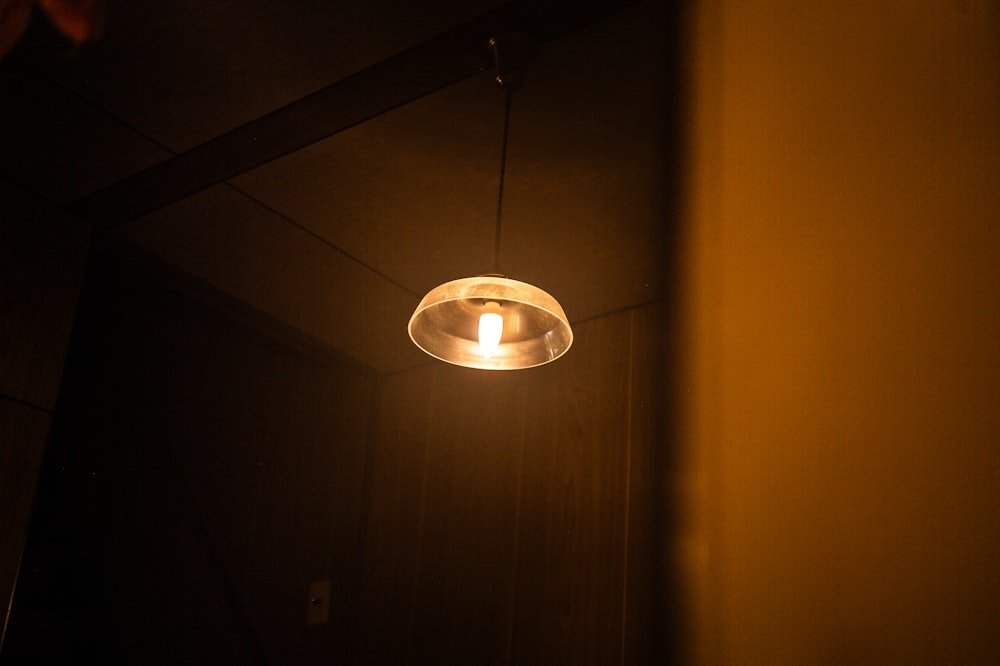 a light hanging from a ceiling in a dark room