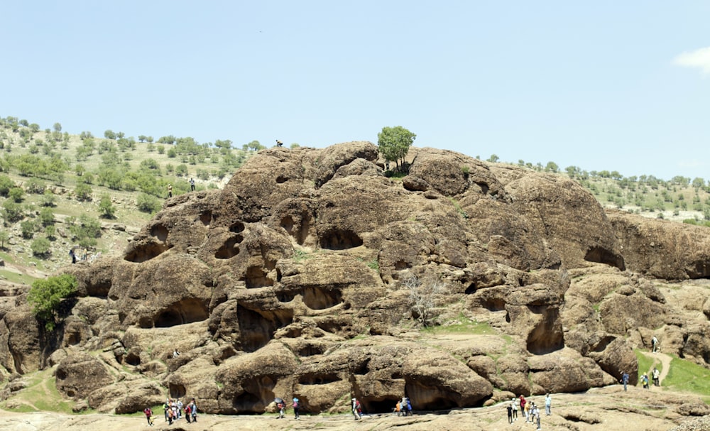 a group of people standing on top of a rocky hillside