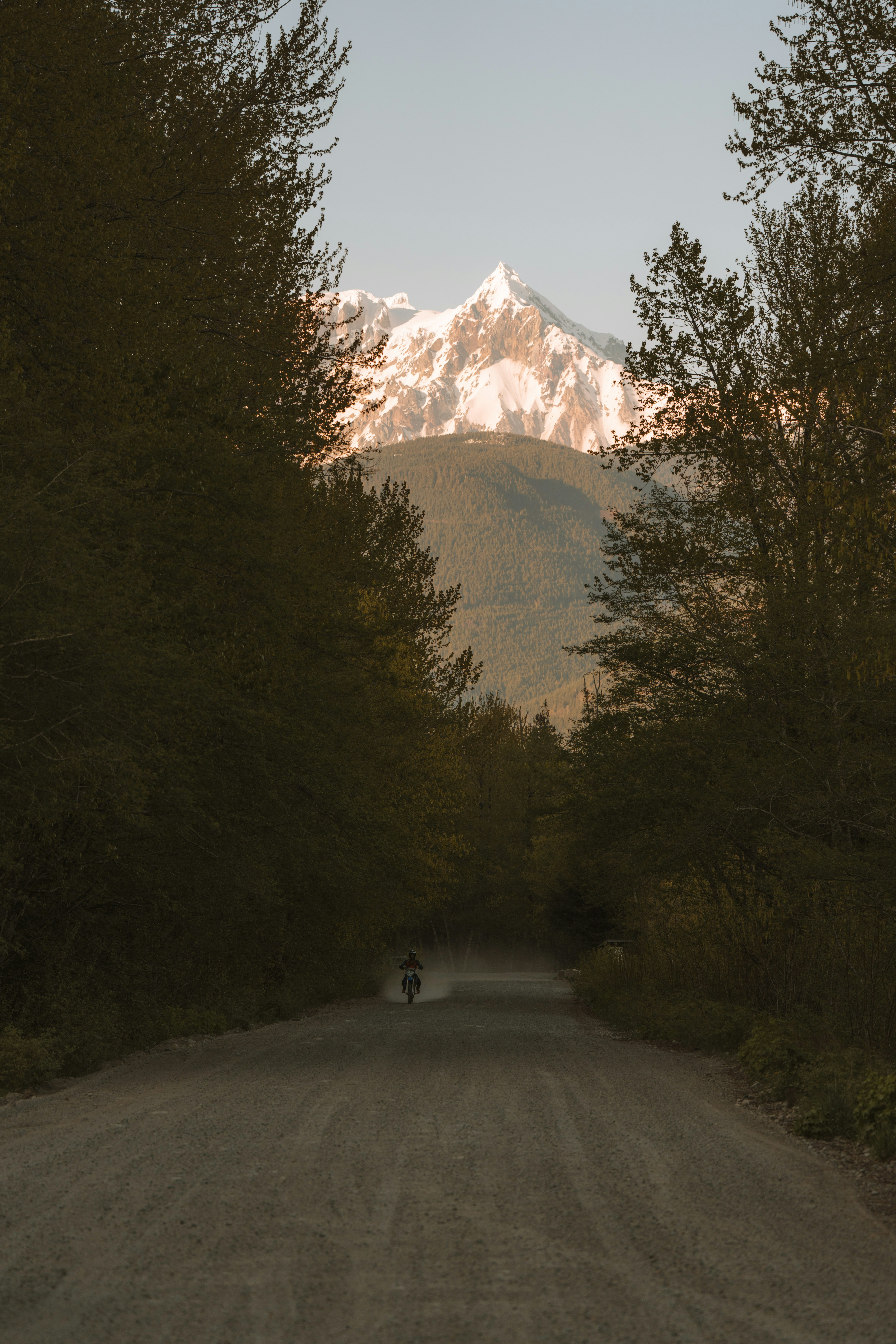 a person riding a bike down a dirt road