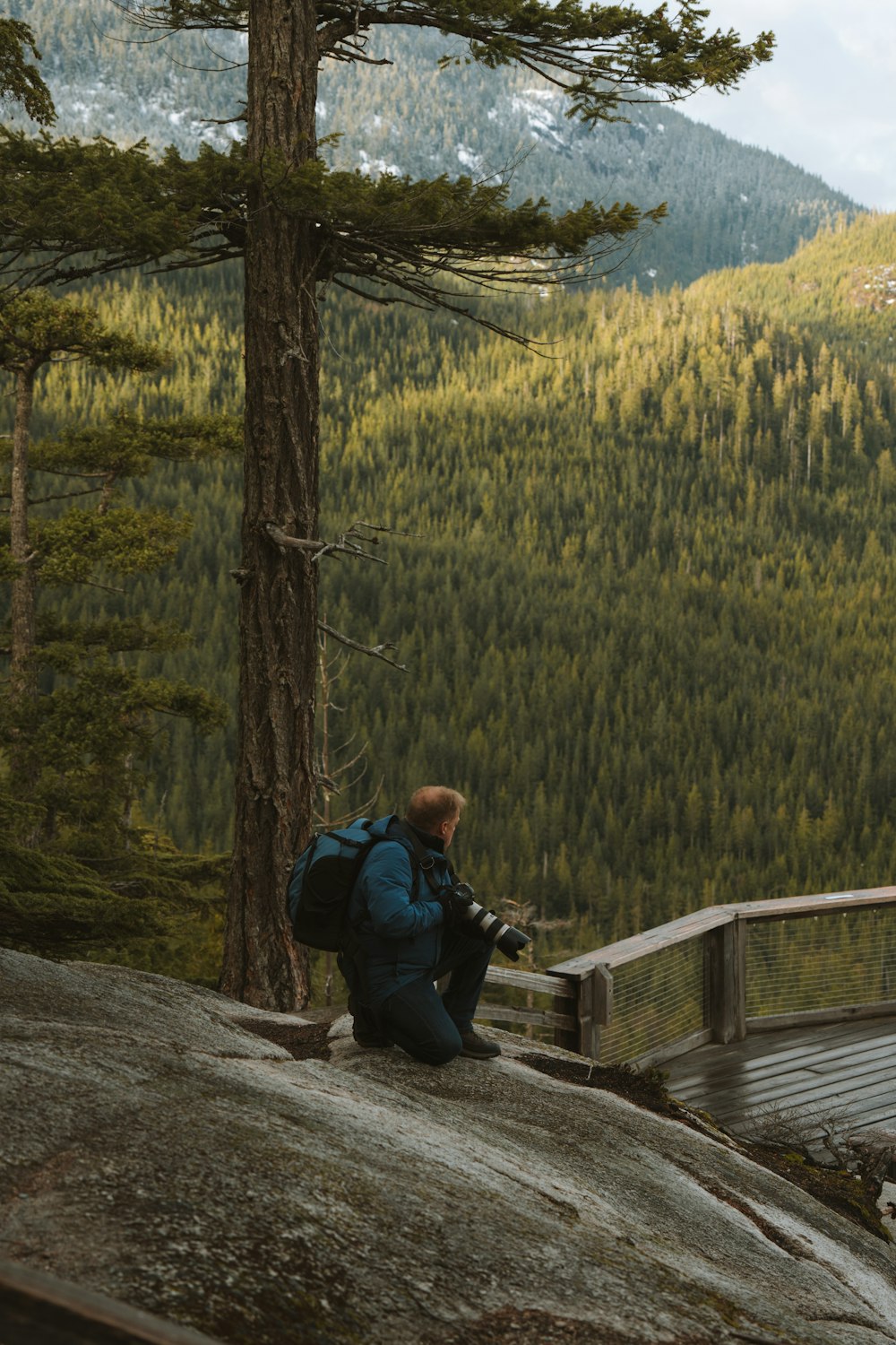 a person sitting on a rock with a backpack