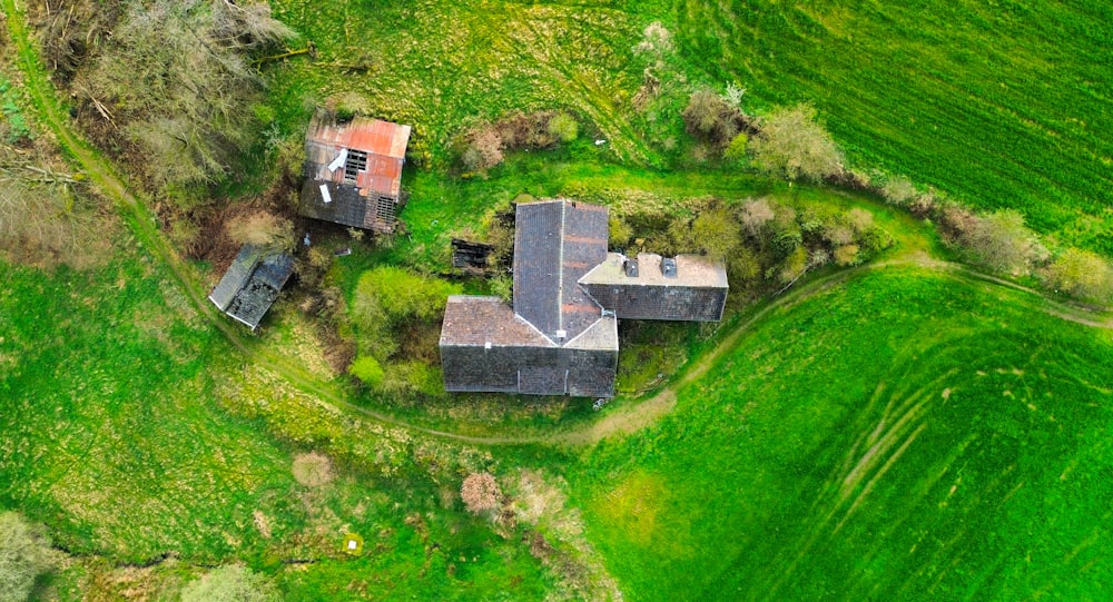 an aerial view of a house in a green field