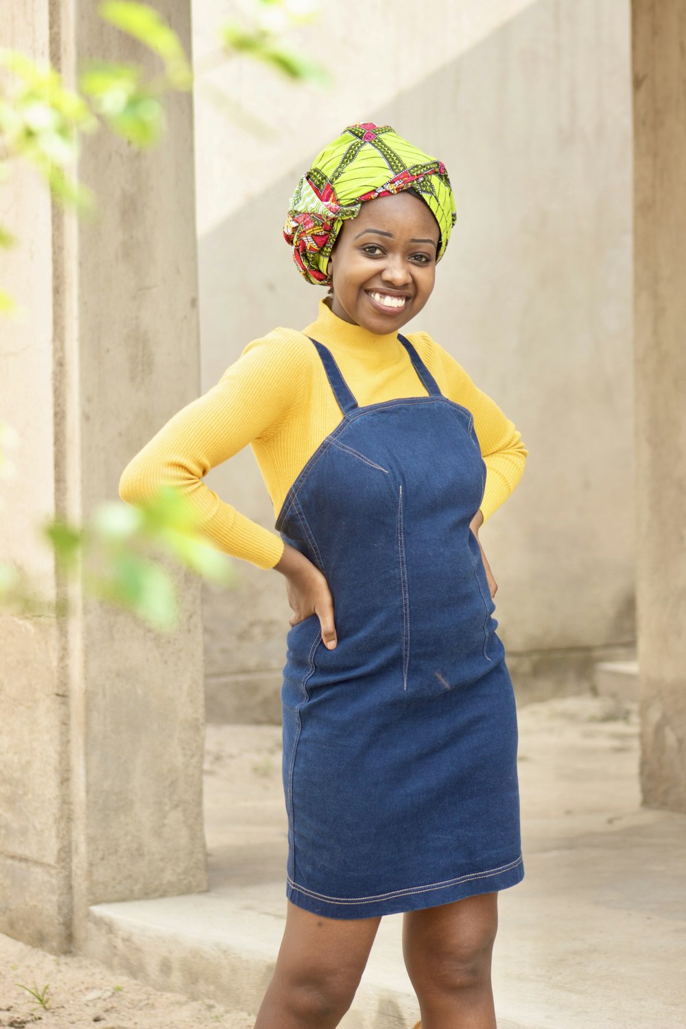 a woman wearing a blue denim dress and a yellow top