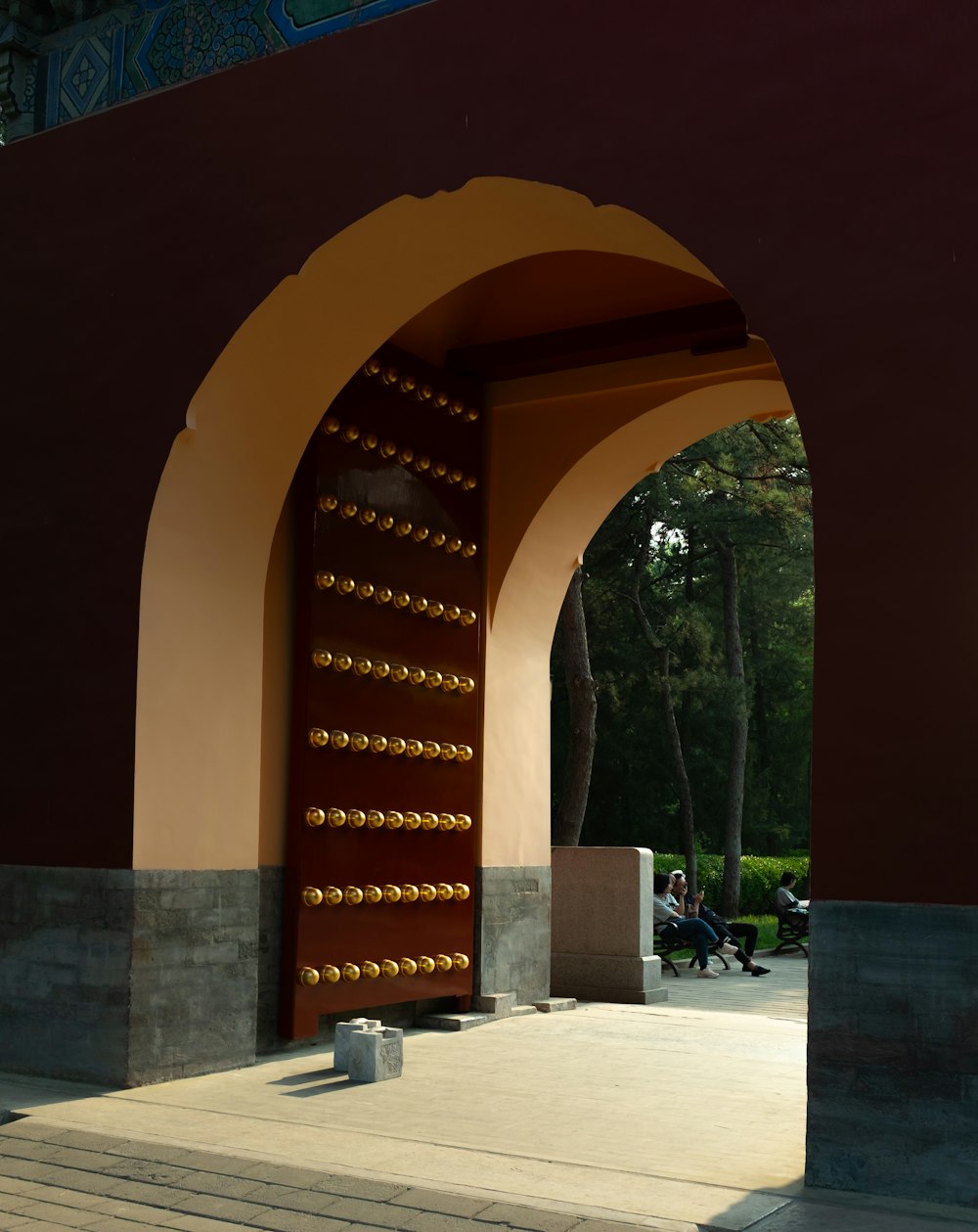 a large archway with a bench in front of it