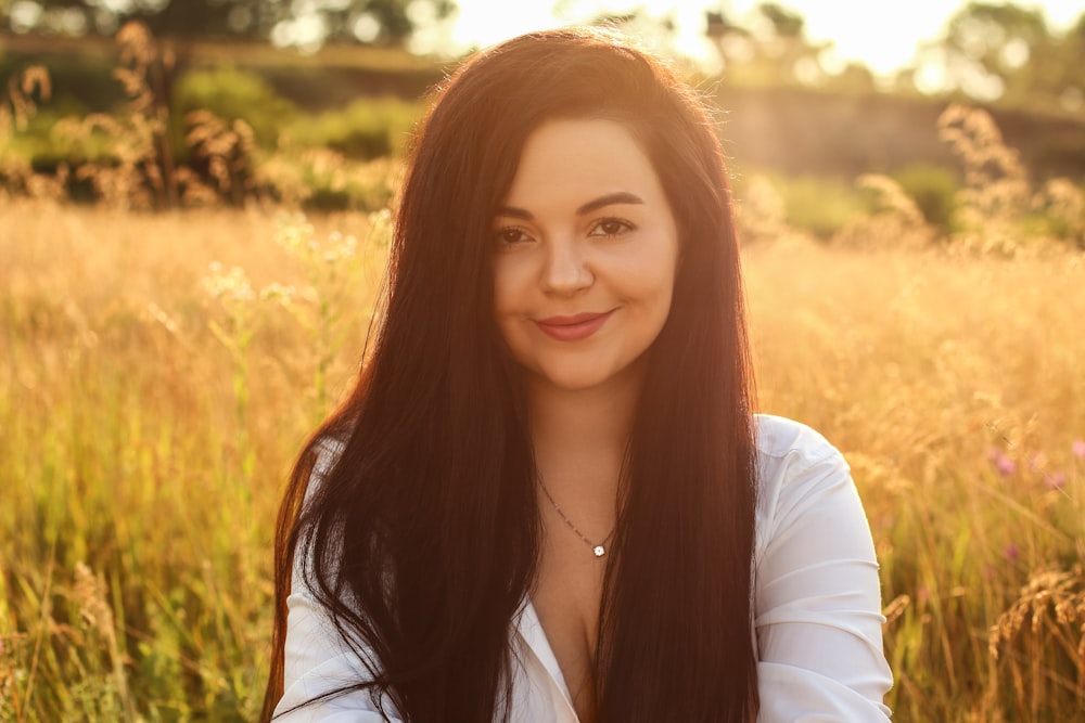 a woman standing in a field of tall grass