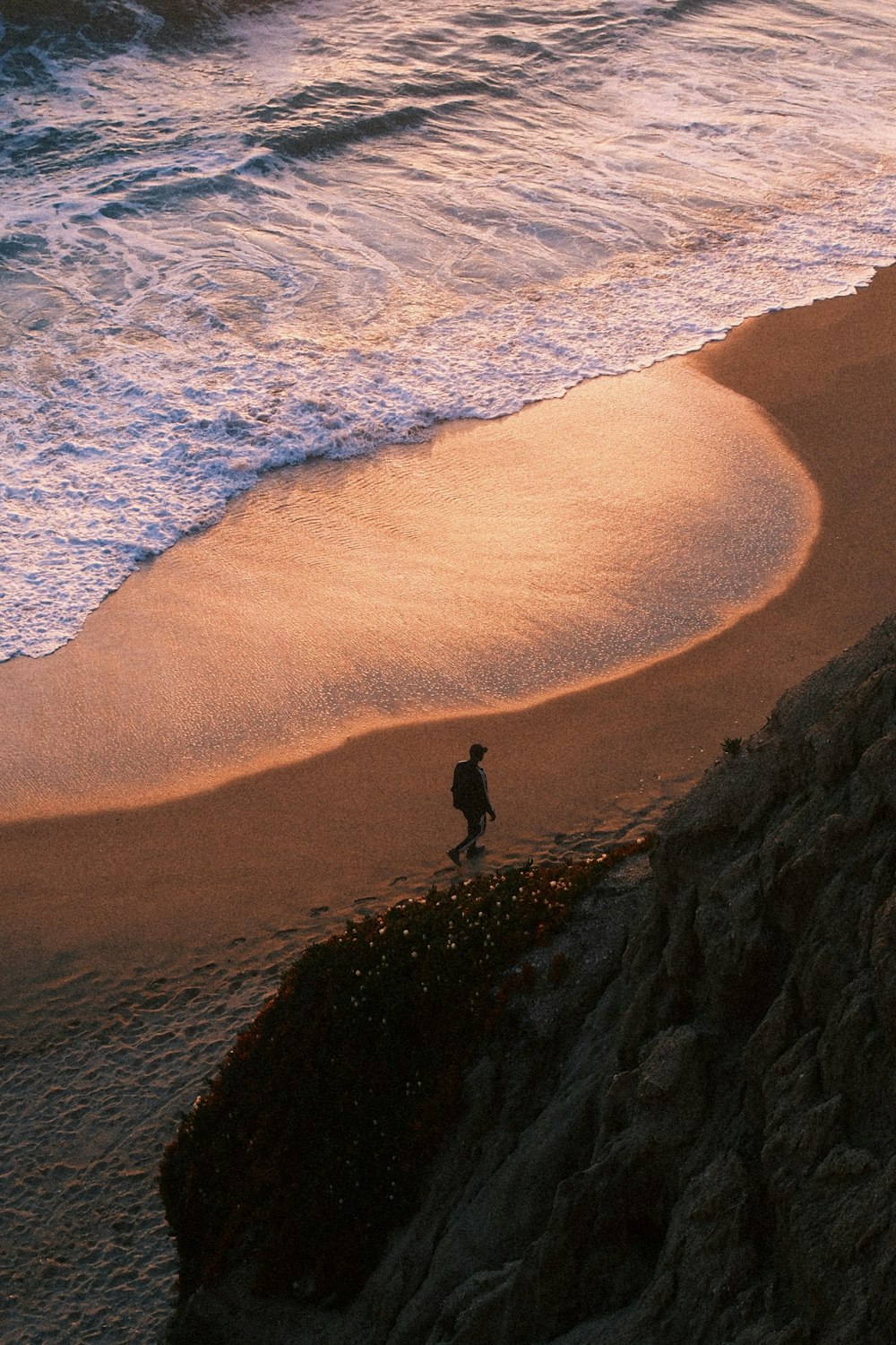 a person standing on a beach next to the ocean