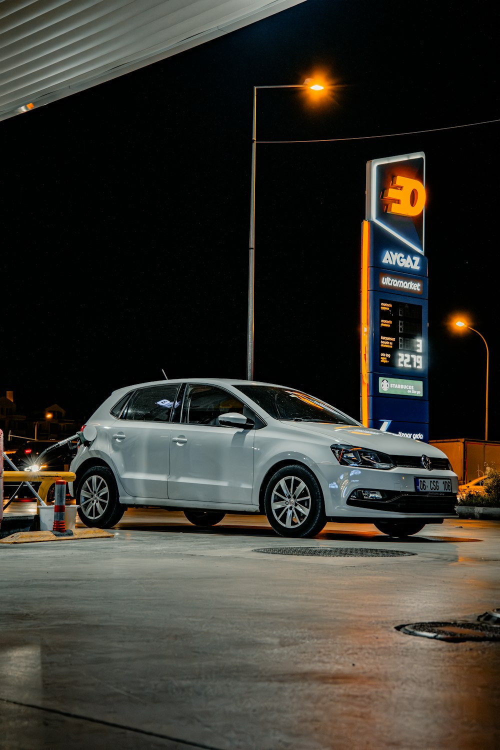 a white car parked in front of a gas station