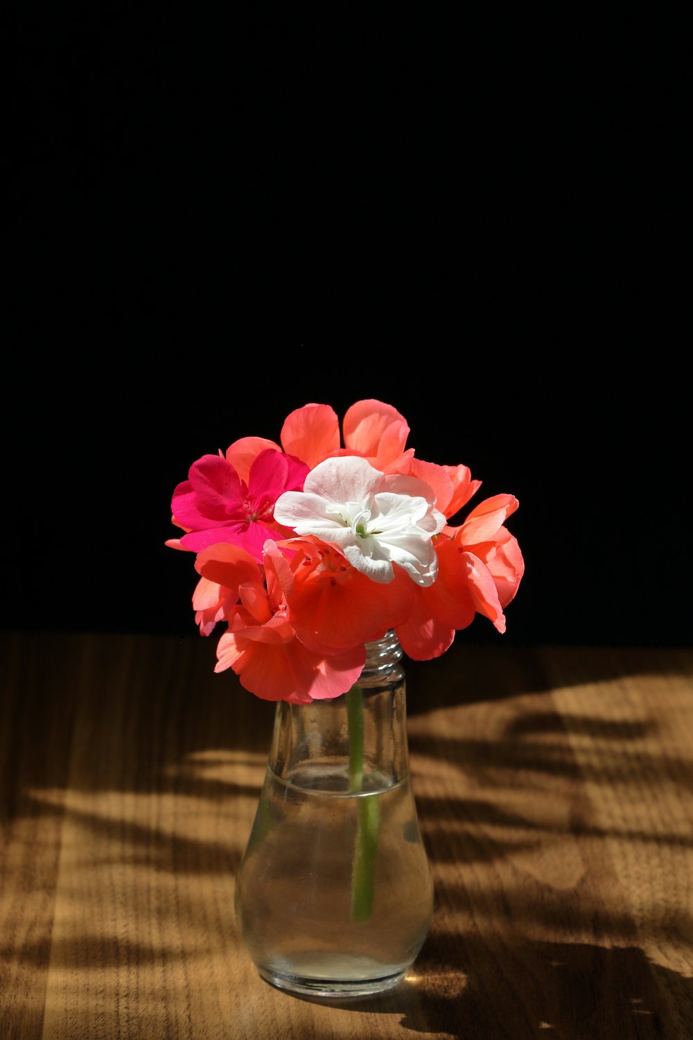 a vase filled with flowers on top of a wooden table