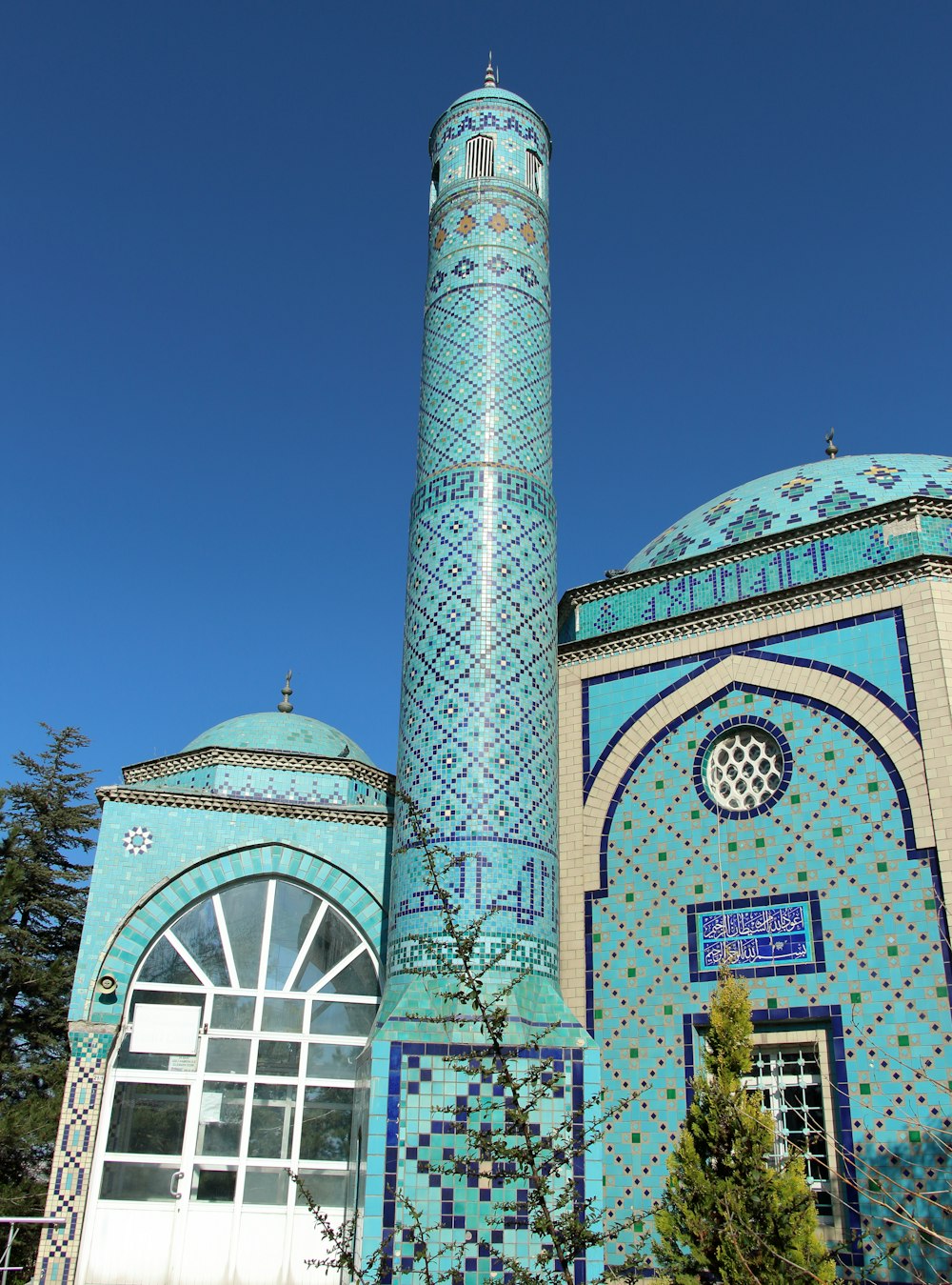 a tall blue building with a blue sky in the background