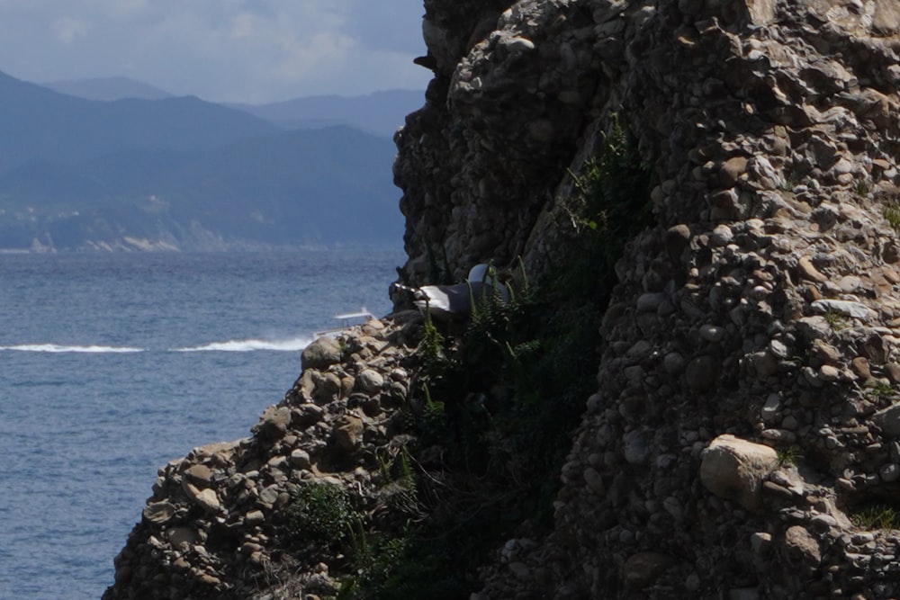 a boat is in the water near a rocky outcropping