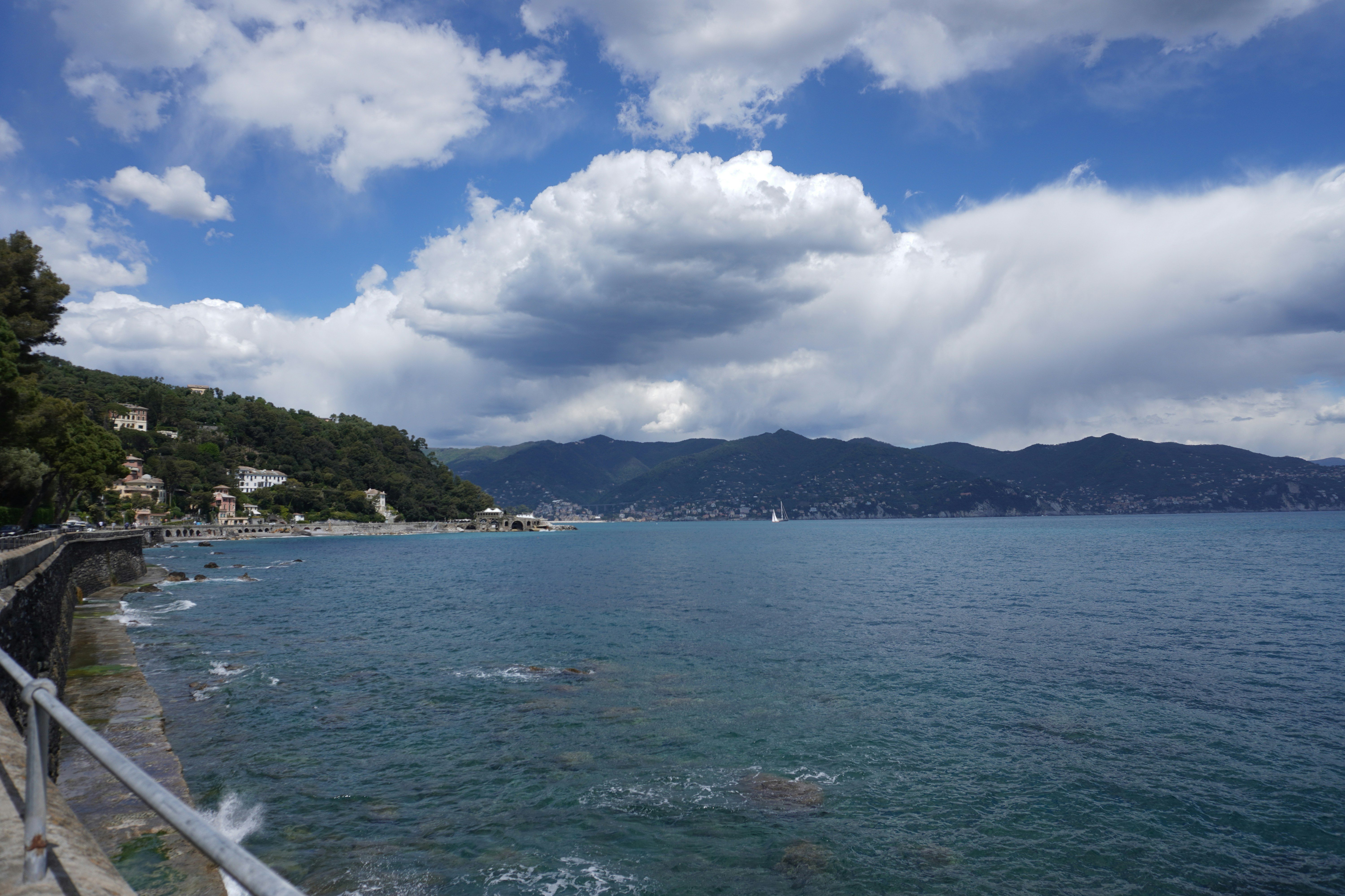 a large body of water with mountains in the background, Panorama view of the seaside city, mountains on the horizon, Portofino