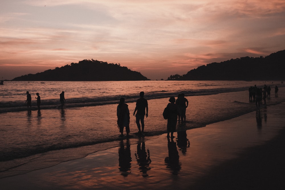 a group of people standing on top of a beach