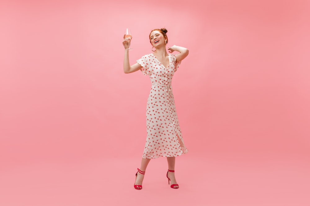 a woman in a white dress holding a wine glass