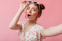 a woman with sunglasses on her head and a surprised look on her face