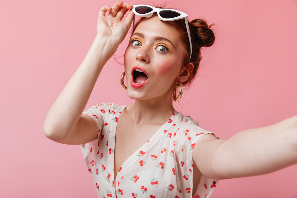 a woman with sunglasses on her head and a surprised look on her face