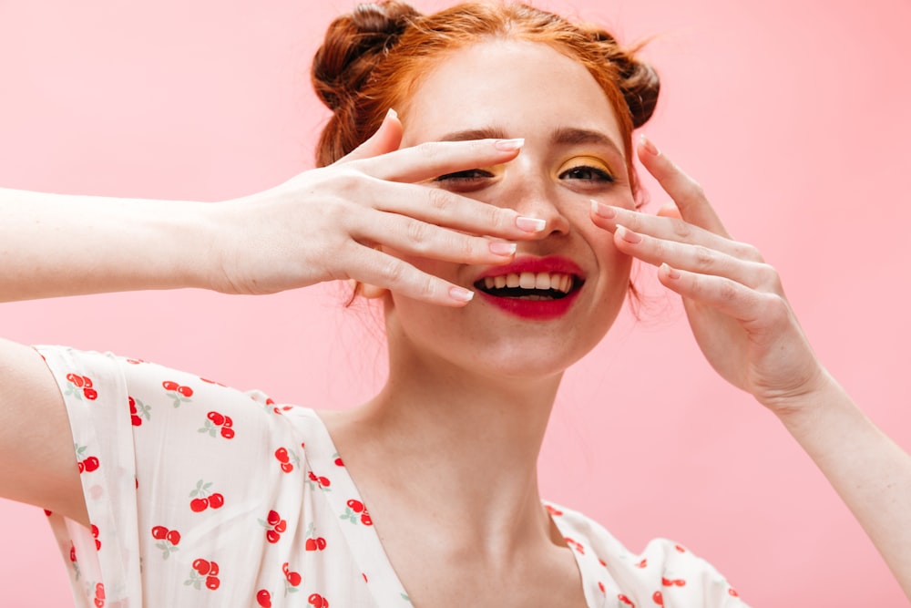 a woman holding her hands up to her face