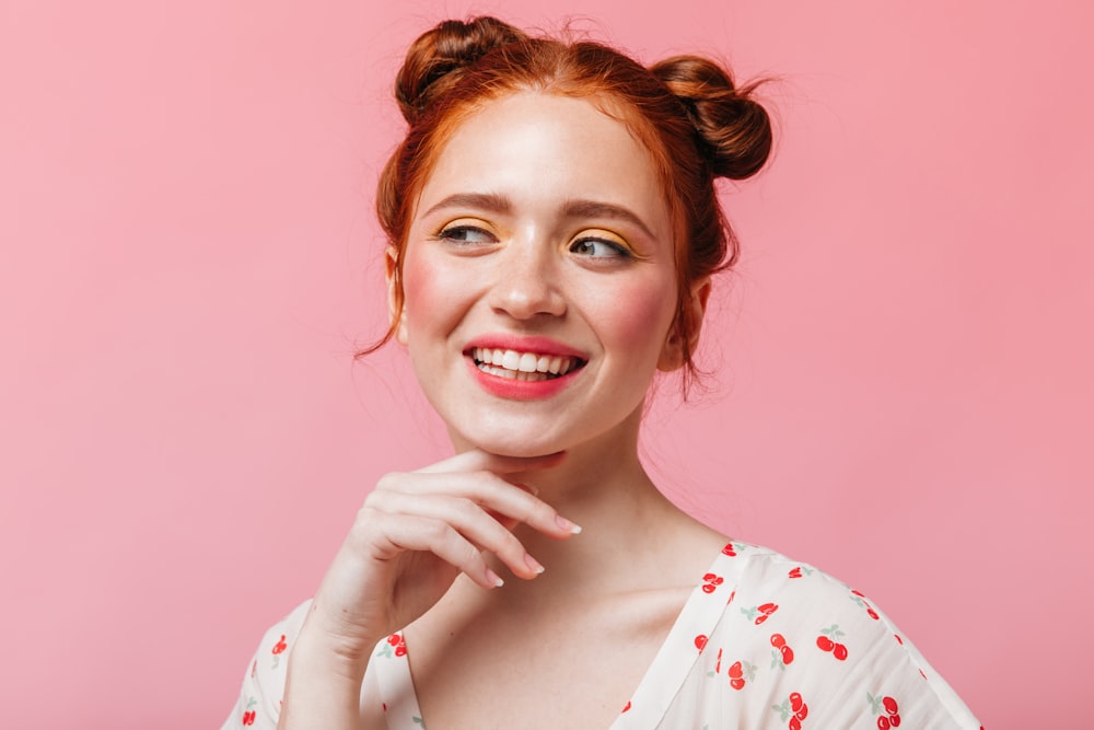 Una donna con i capelli rossi sorride e posa per una foto