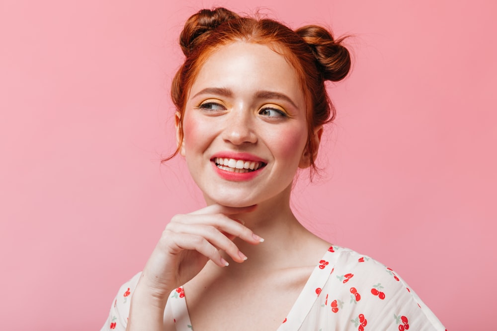 Eine Frau mit roten Haaren lächelt und posiert für ein Foto