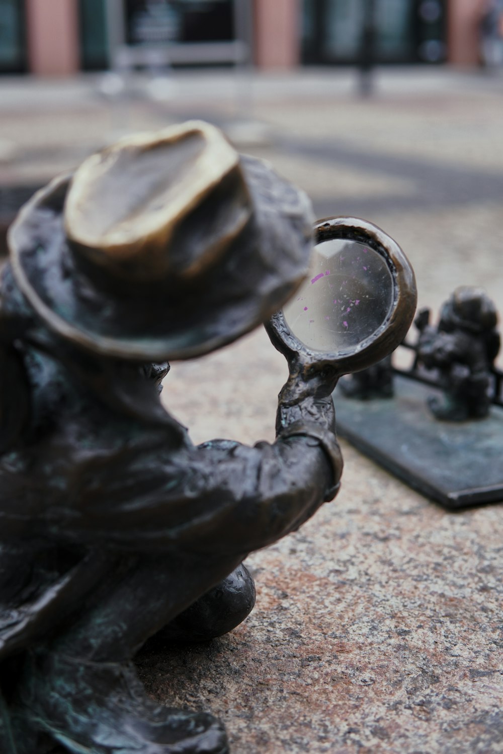 a statue of a man holding a magnifying glass