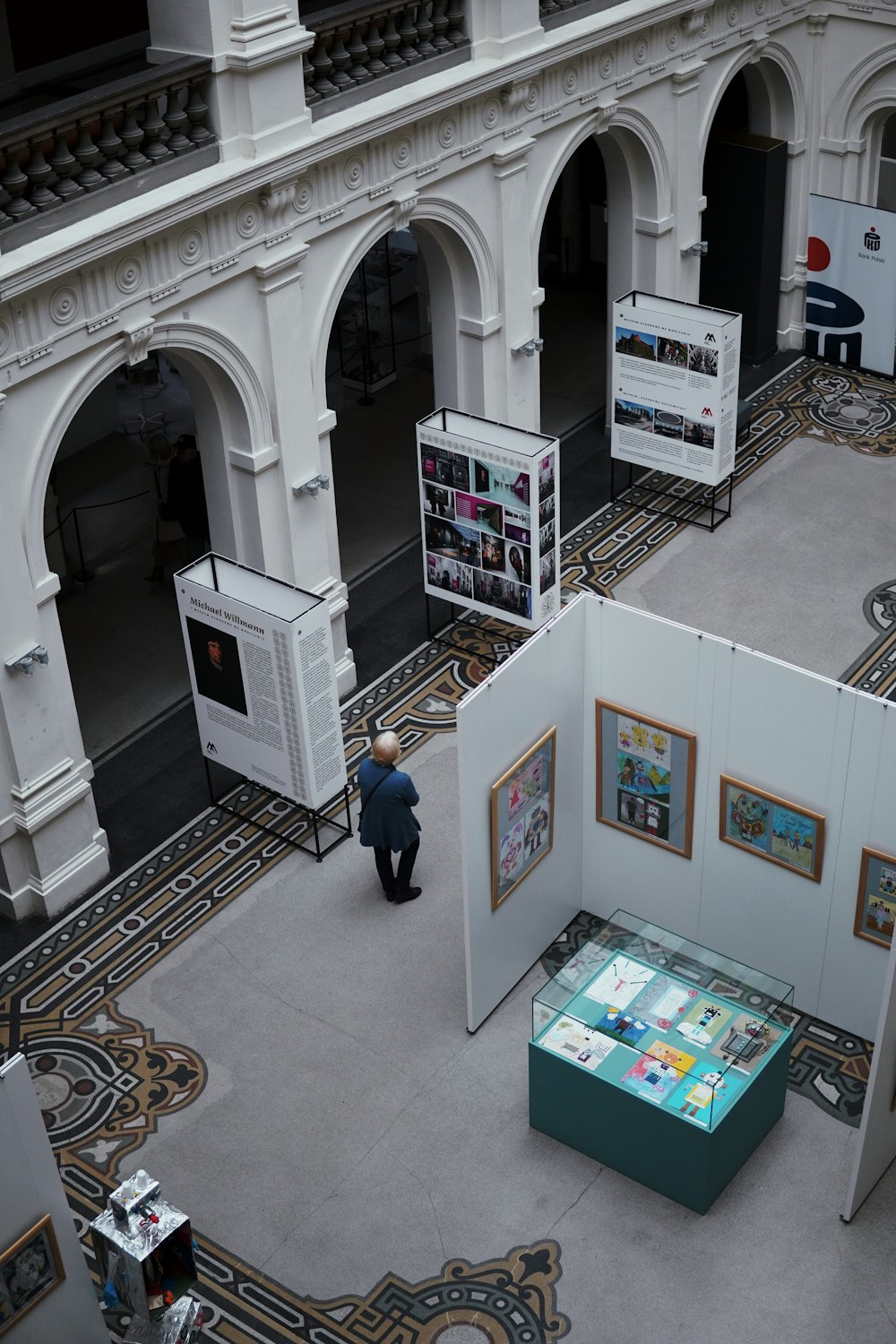 a man standing in a museum looking at a display