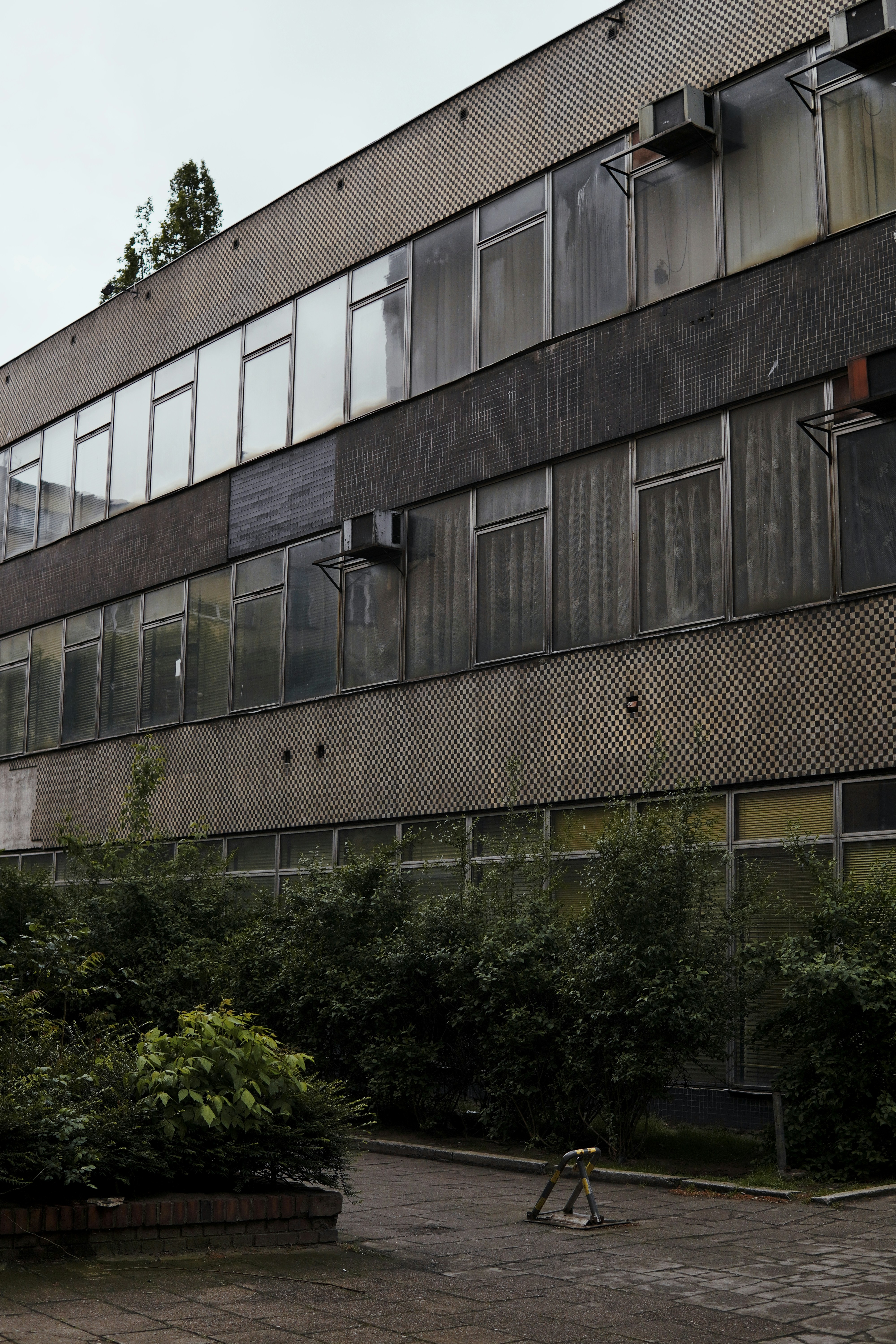a large building with lots of windows next to trees
