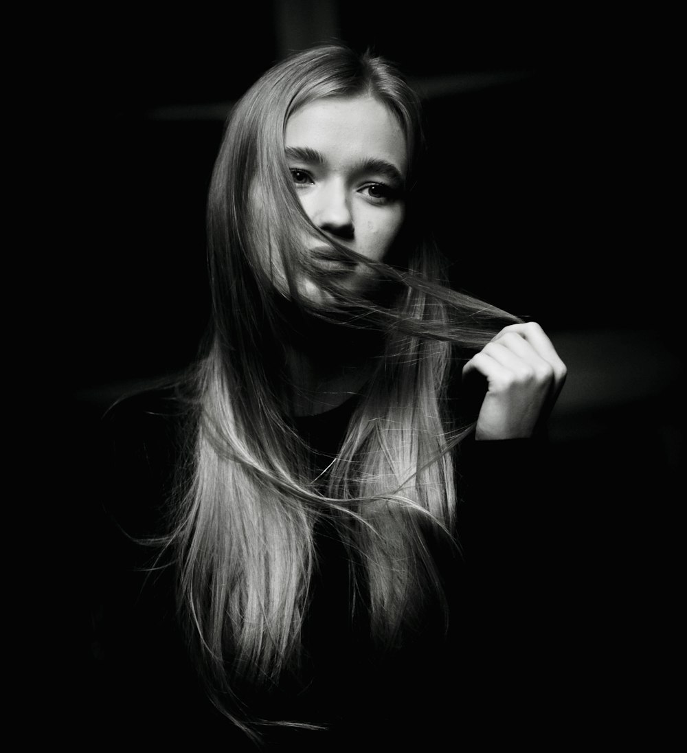 a woman brushing her long hair with a brush