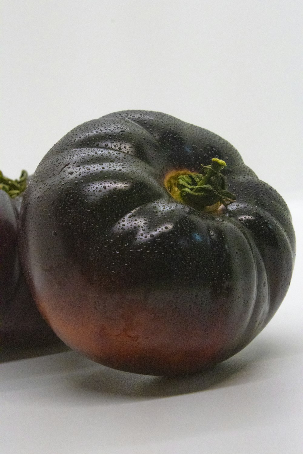 a couple of black tomatoes sitting on top of a white table