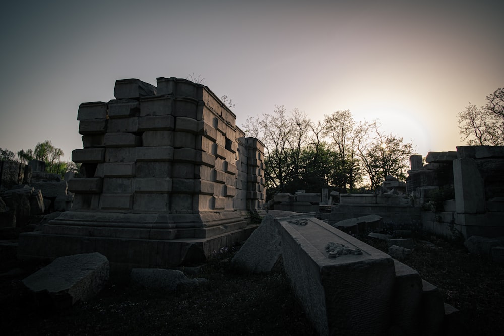 the sun is setting over the ruins of a cemetery