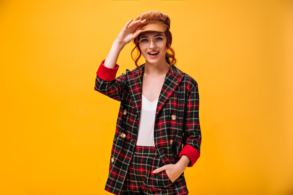 a woman wearing a plaid jacket and hat