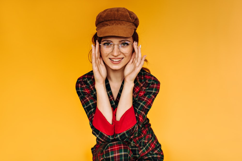 a woman with a hat and glasses posing for a picture