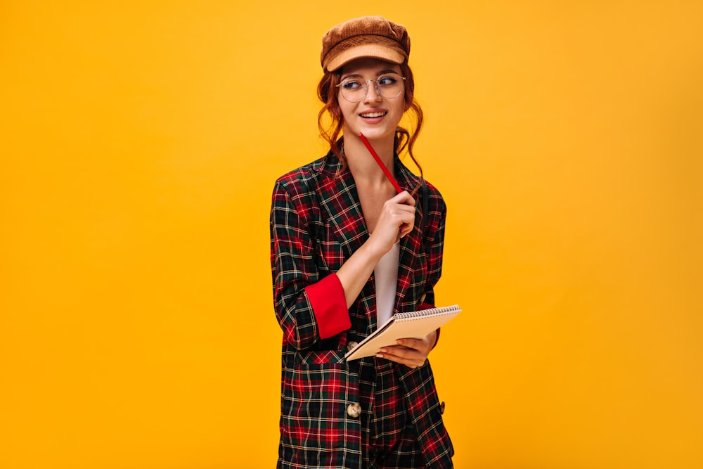 a woman holding a book and a pen in her hand