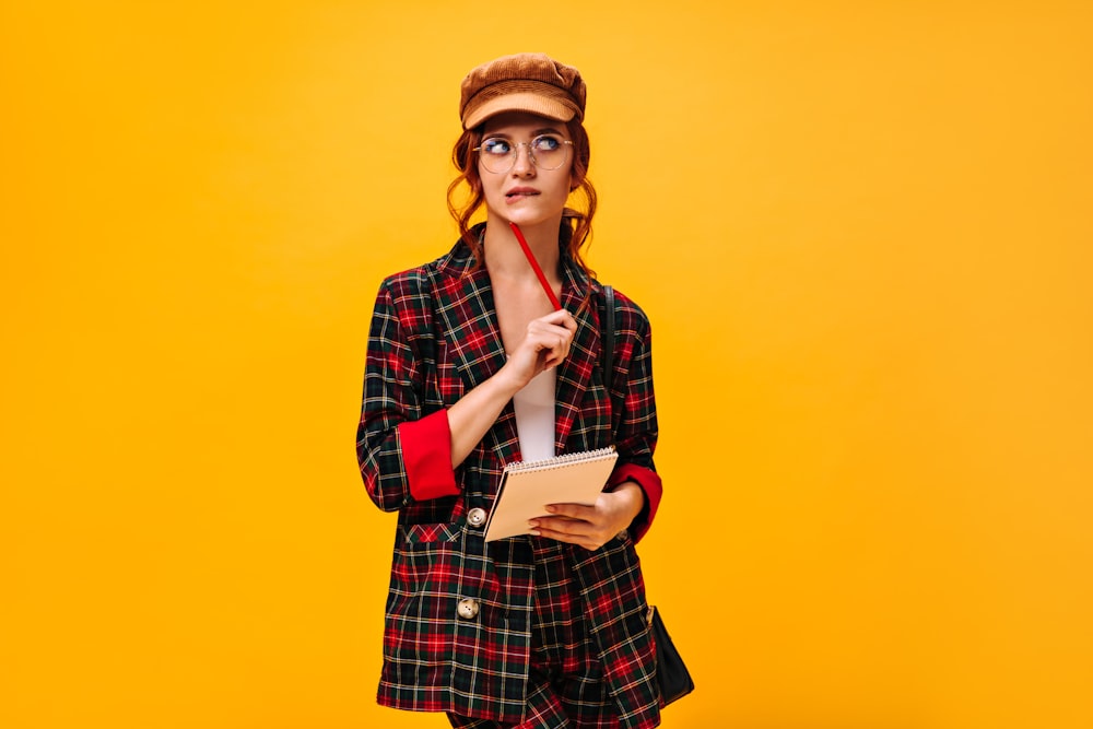 a woman in a plaid suit holding a red umbrella