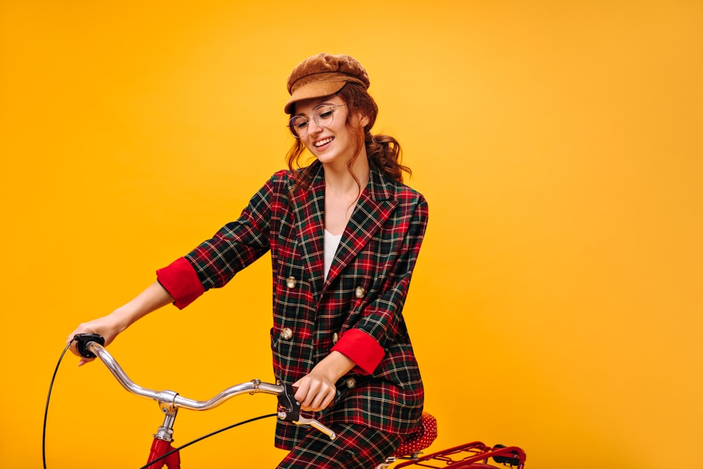 a woman in a plaid suit riding a bicycle
