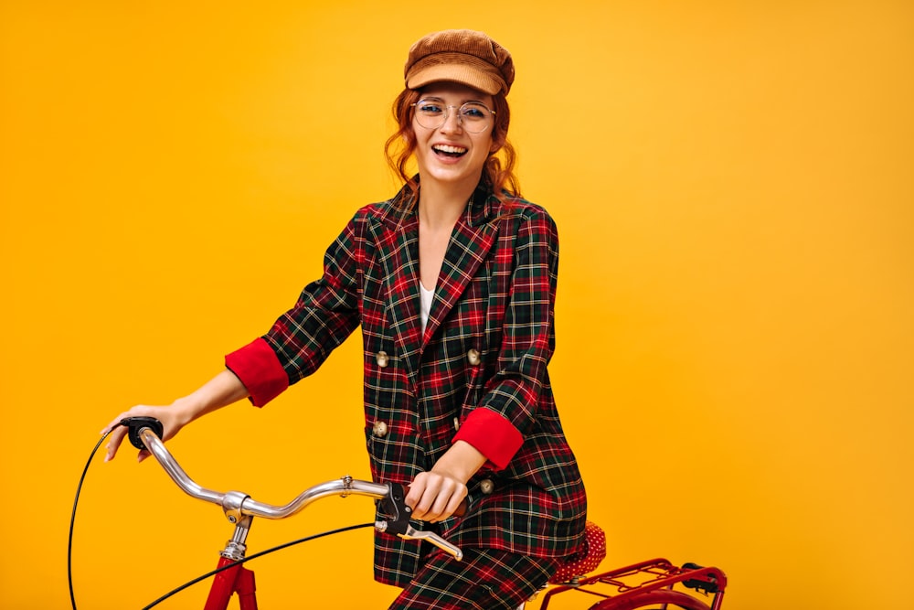 a woman in a plaid suit riding a bicycle