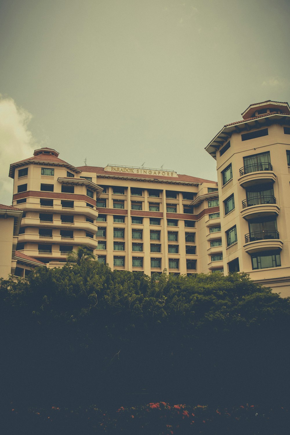 a tall building sitting next to a lush green hillside