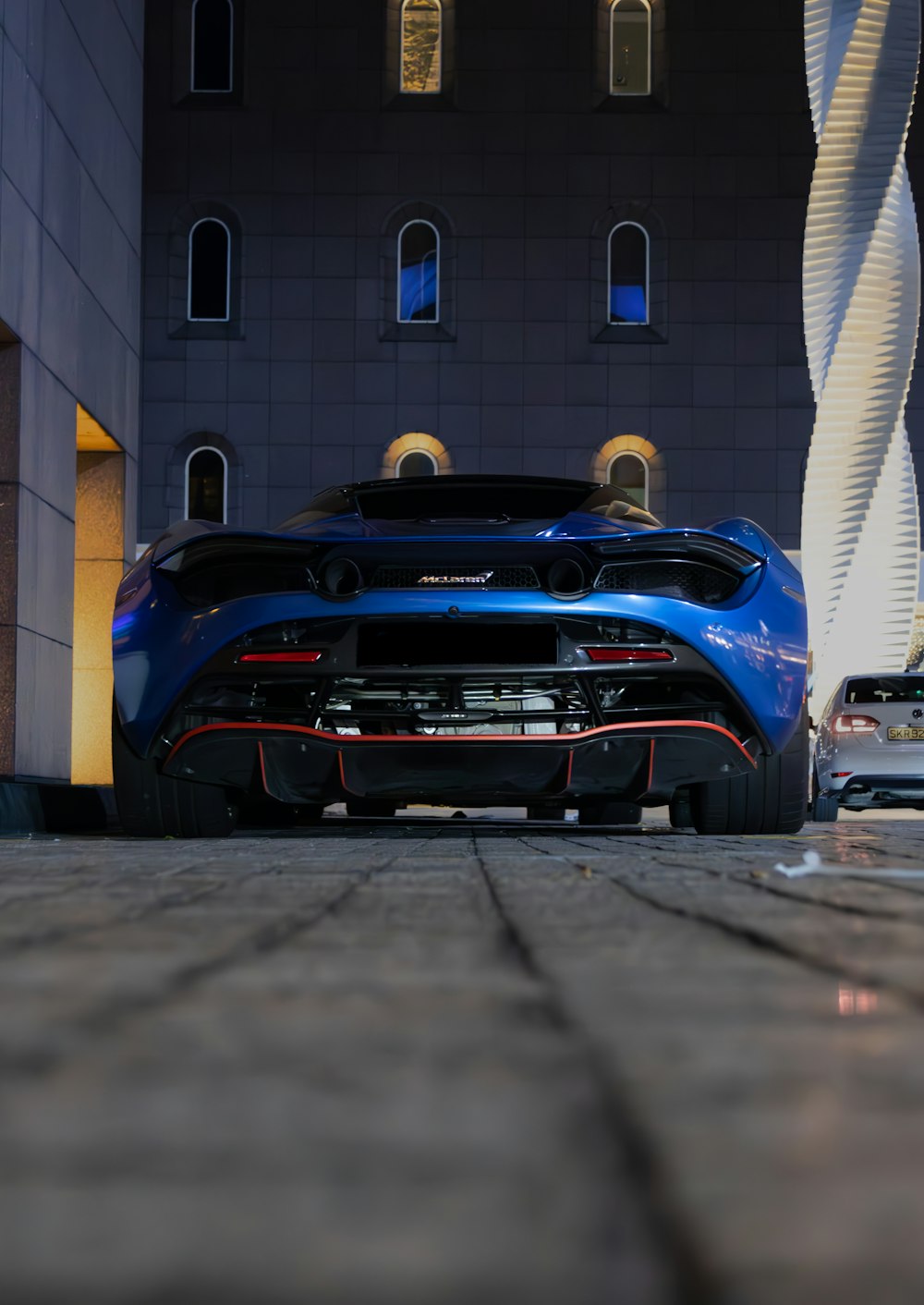 a blue sports car parked in front of a building