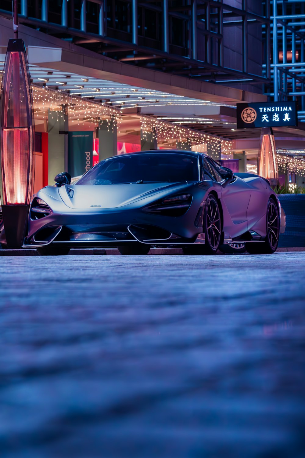 a purple sports car parked in front of a building