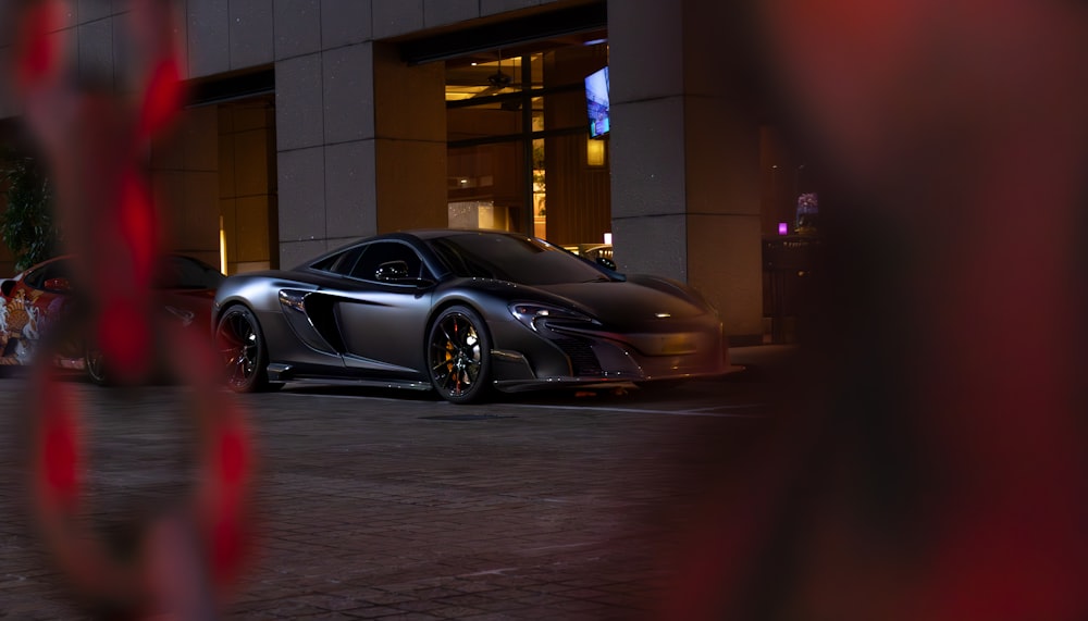 a black sports car parked in front of a building