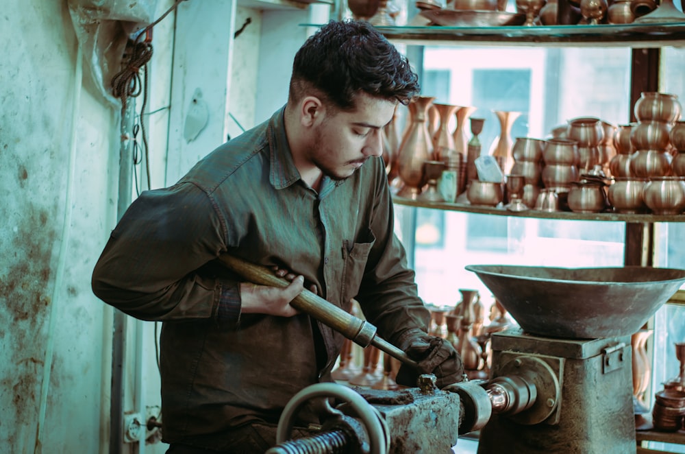 a man working on a machine in a pottery shop